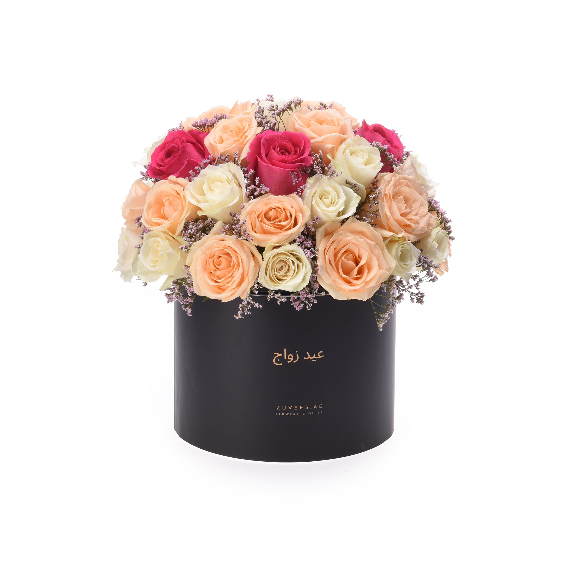 Black box holds vibrant peach, pink, and cream roses with delicate purple filler blooms.