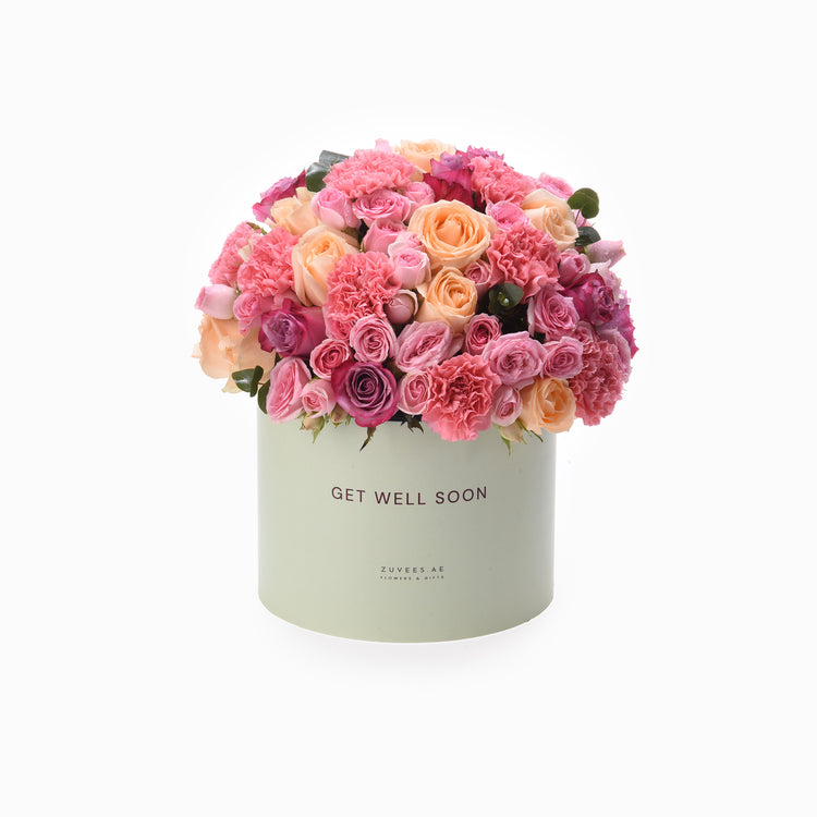 Pastel pink roses and carnations bloom in mint-green "Get Well Soon" box.