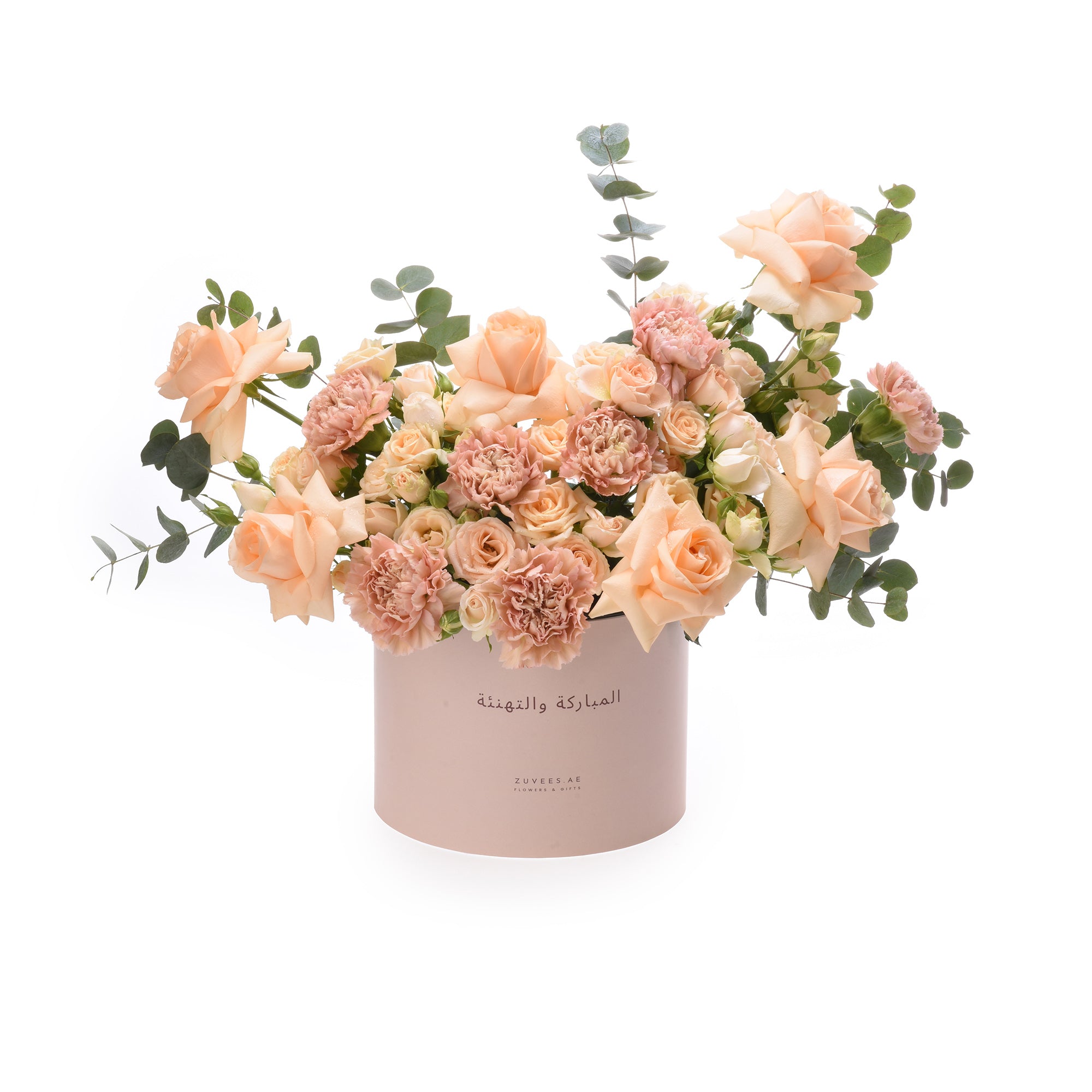 Soft peach roses and carnations in a branded pink box with Arabic greeting.