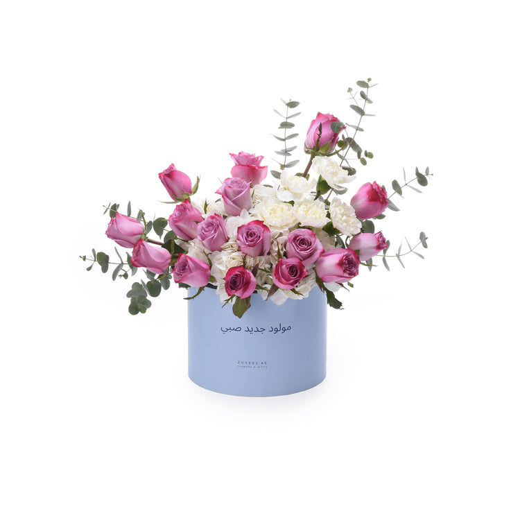 Light blue box holds pink roses and white blooms with eucalyptus.