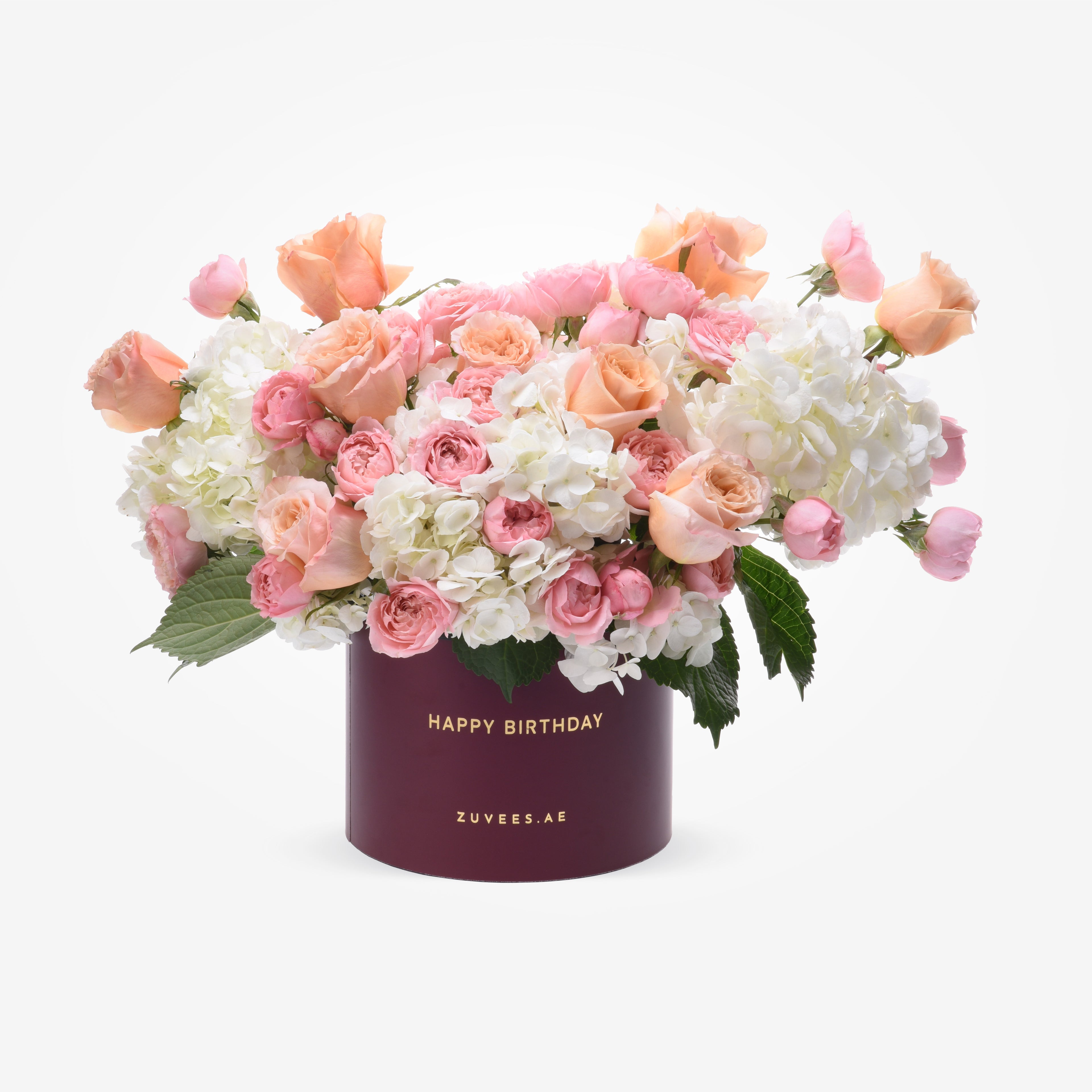 Soft pink roses and white hydrangeas in burgundy box with "Happy Birthday" gold text.