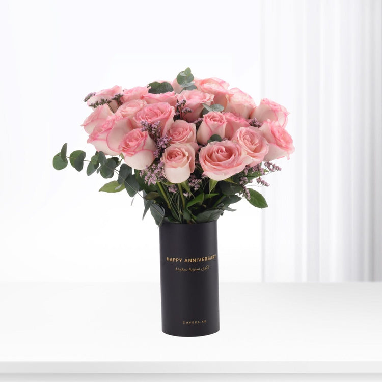 Pink roses in black anniversary vase with gold text.