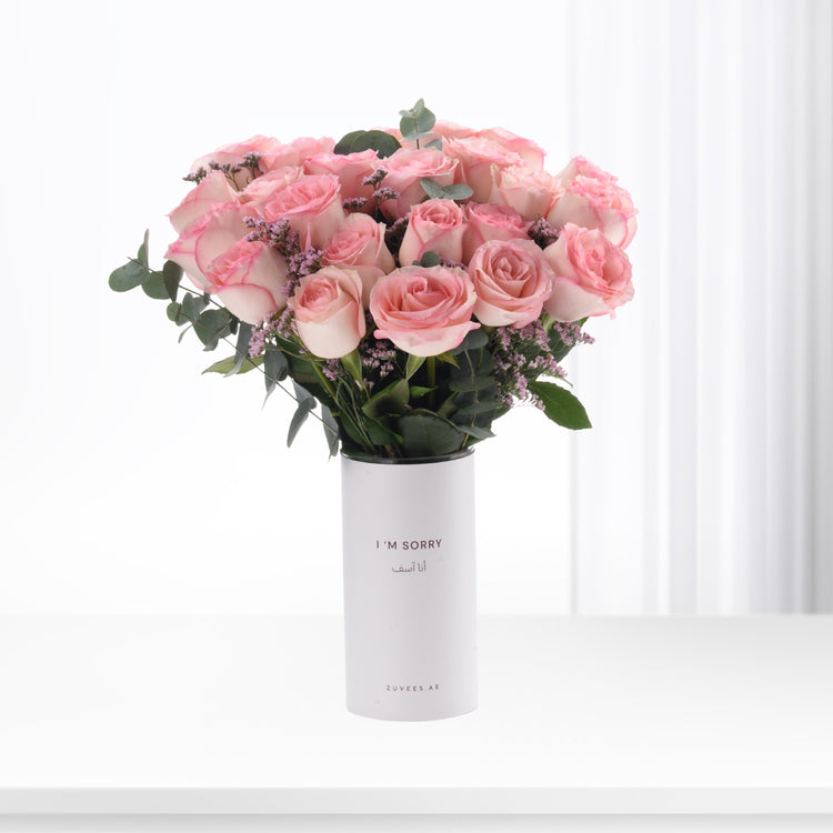 Soft pink roses in minimalist white vase with bilingual apology message.