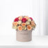 Pastel pink, peach, and magenta roses in a beige "Happy Birthday" box.