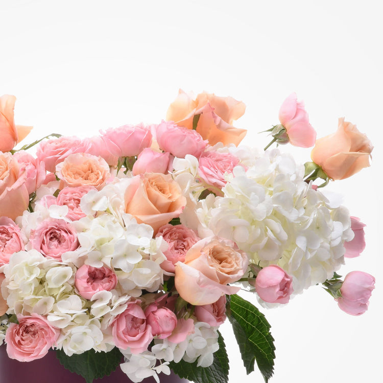 Soft peach roses and white hydrangeas in lush, romantic bouquet.