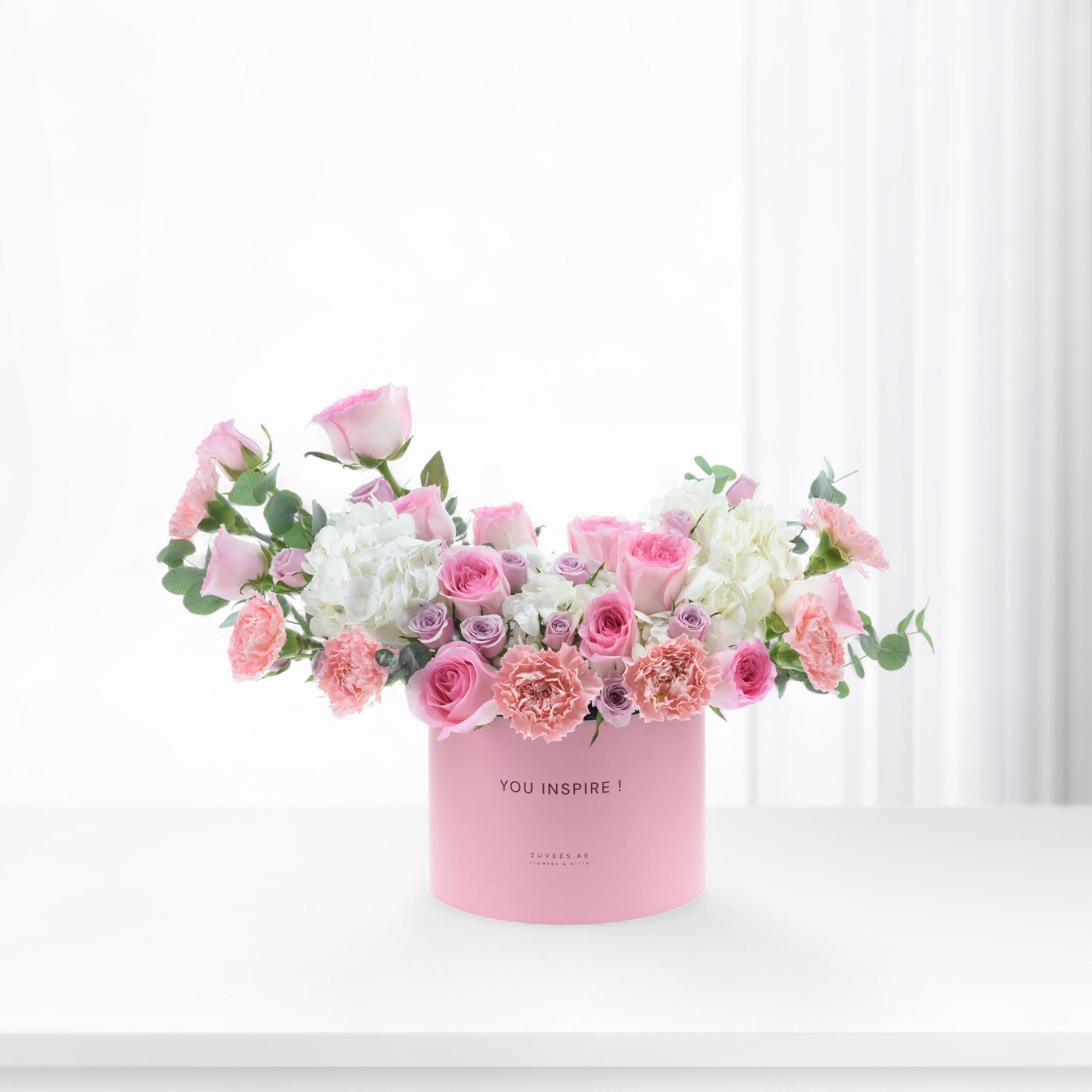 Pink floral arrangement in box with "YOU INSPIRE!" text.