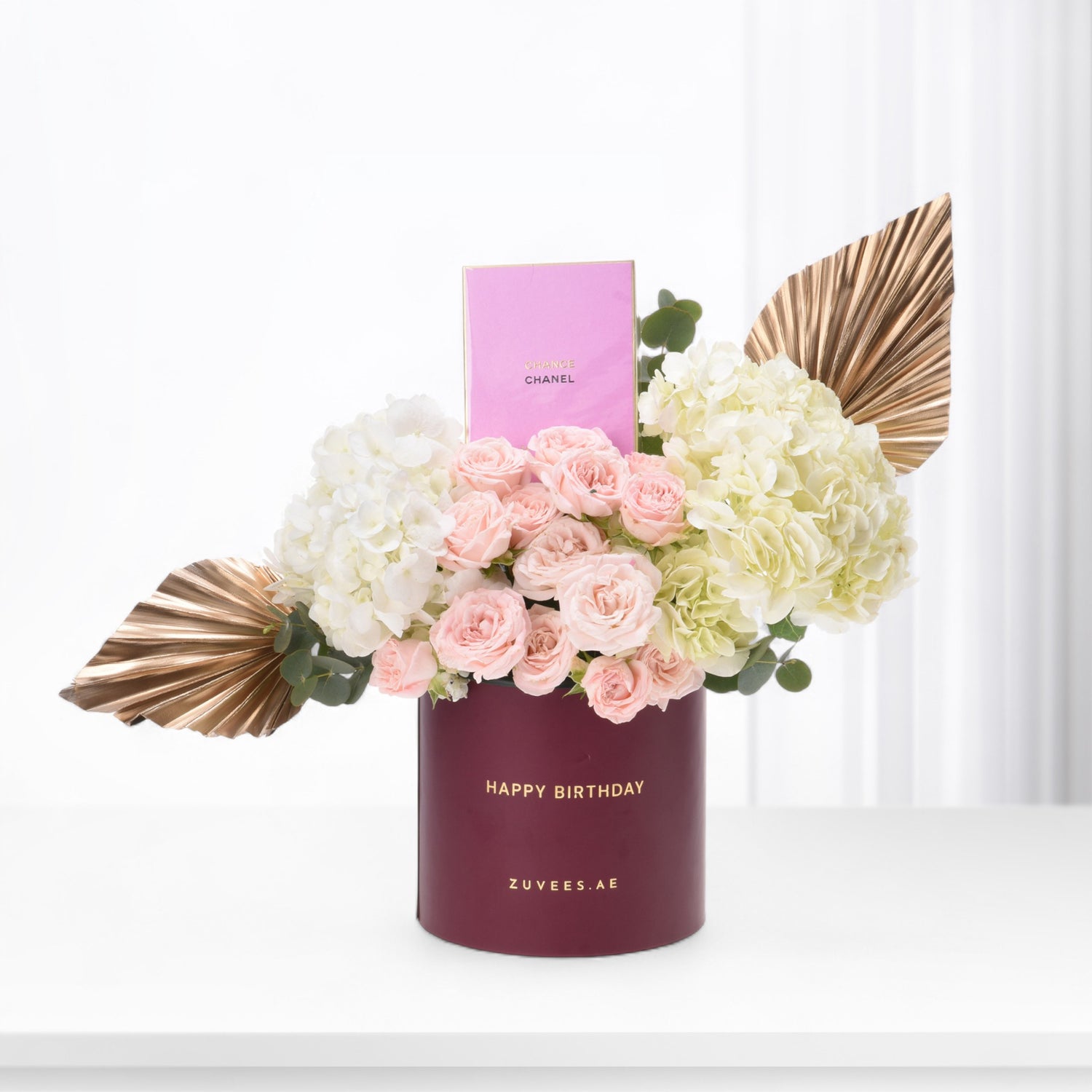 Elegant birthday bouquet in burgundy box with pink roses, hydrangeas, and gold accents.