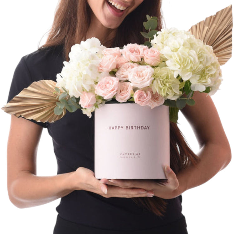 Pink roses and hydrangeas in elegant box with gold accents.