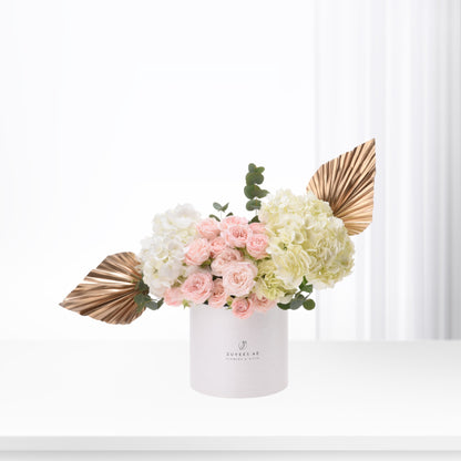 Elegant pink roses and hydrangeas in white box with gold leaf accents.