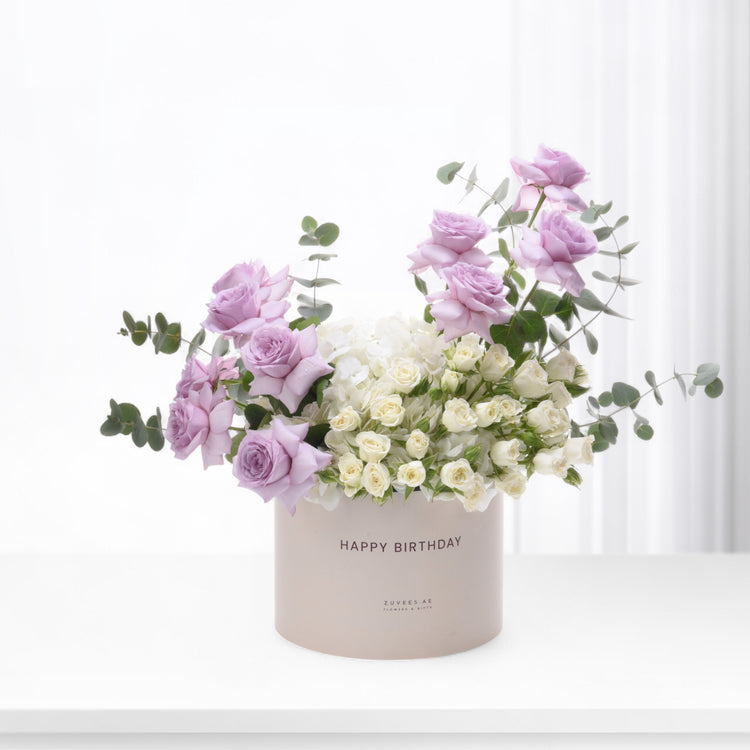 Pastel pink roses and white blooms in a "Happy Birthday" box.