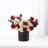 Elegant black box holds vibrant red, white roses and black eucalyptus for anniversary.