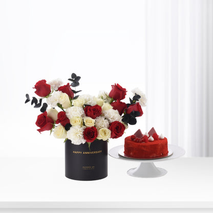 Elegant red, white roses and cake in black anniversary vase.