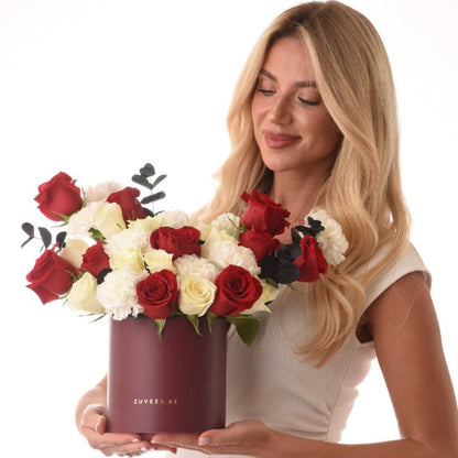 Elegant black box with red and white roses from, paired with fine chocolates of Zuvees Luxe Chocolate, Mirzam and Lakrids — a refined romantic gift.