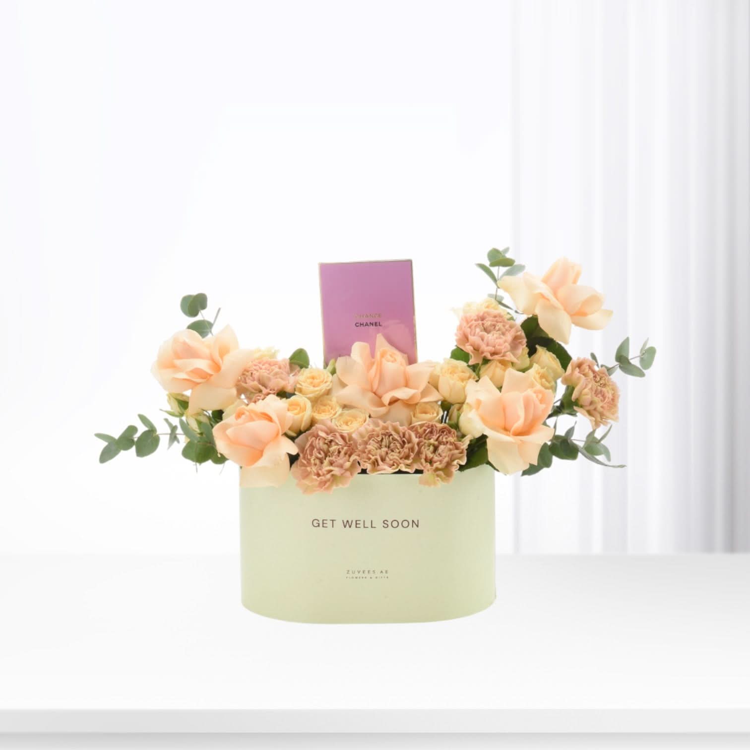 Pastel peach roses and carnations in mint box with "GET WELL SOON" message.