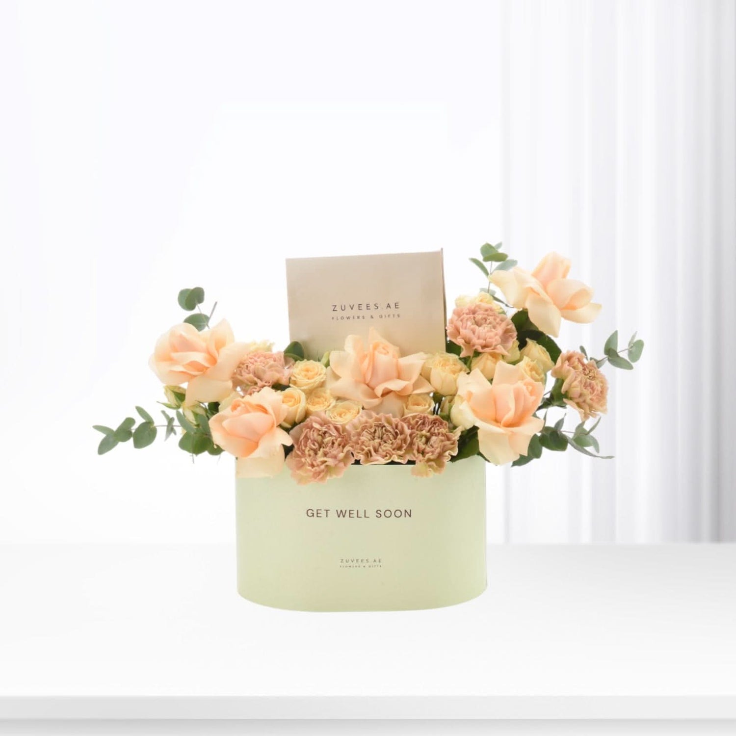 Pastel peach roses and carnations in mint-green "Get Well Soon" box.