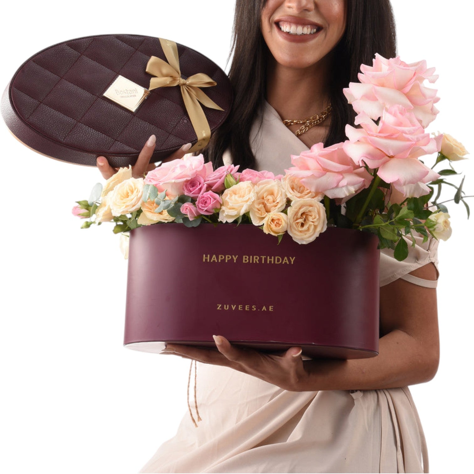 Smiling woman holds burgundy birthday flower box with gold bow and roses.