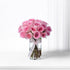 Pink roses in clear vase, ribbon-tied, soft light, elegant arrangement.