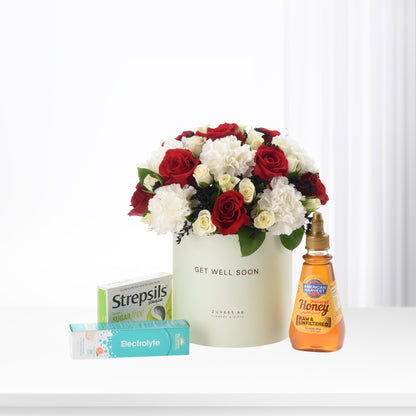 Red and white roses in cream box with honey, throat lozenges, and electrolyte.