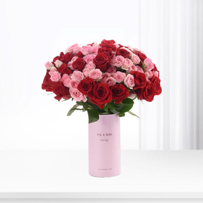 Vibrant red and pink roses in light pink “It’s a Girl” vase.