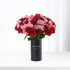 Vibrant red and pink roses in matte black vase with "You Are My World" text.
