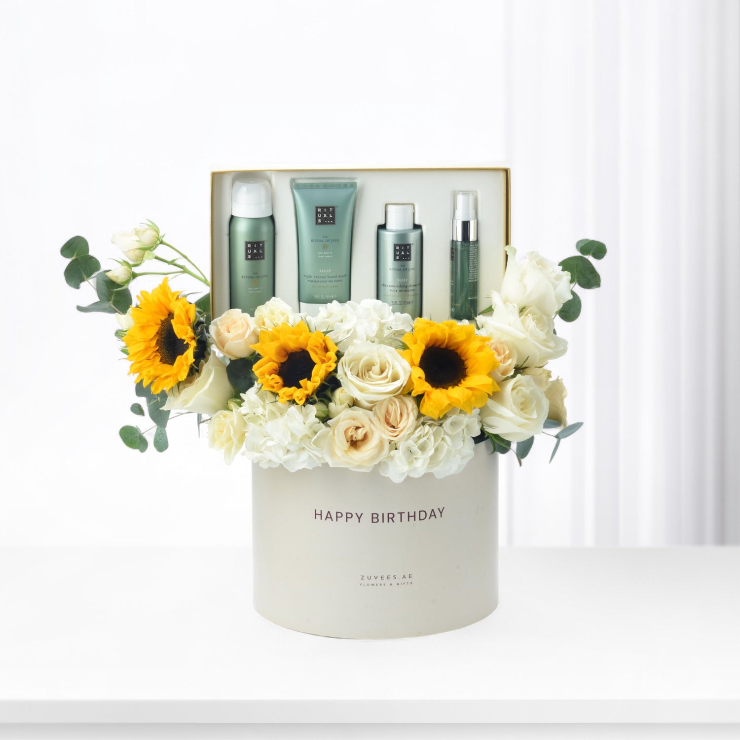 White box with "Happy Birthday," sunflowers, roses, and Rituals skincare set.