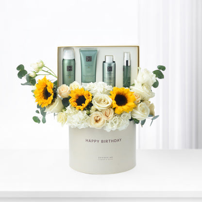 White box with "Happy Birthday," sunflowers, roses, and Rituals skincare set.