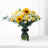 Vibrant yellow sunflowers and roses in clear vase with black ribbon.
