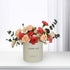 Pastel peach roses and red carnations in cream box with "Thank You" text.
