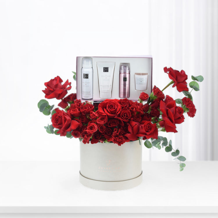 Luxurious red roses surround a Rituals spa gift set in elegant ivory box.