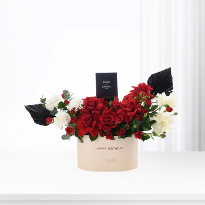Elegant red and white floral arrangement with Chanel perfume in beige birthday box.