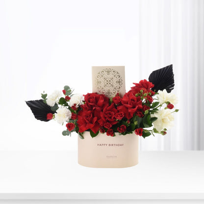 Elegant red and white floral arrangement in beige box with "Happy Birthday" text.