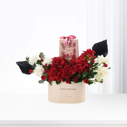 Elegant red and white rose bouquet in cream box with "Happy Birthday" text, black leaves, pink gift box.