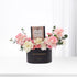 Elegant black anniversary gift box with pink roses, white blooms, and caramel chocolates.