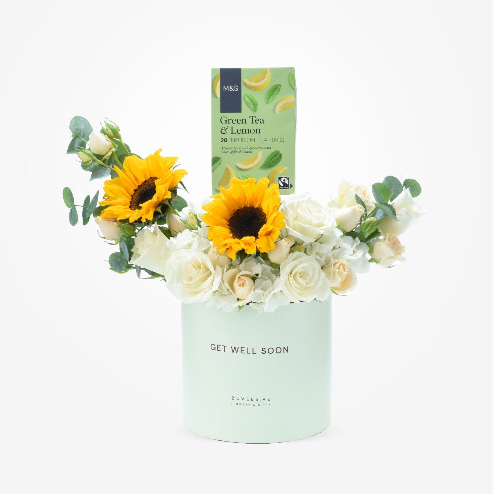 Pastel mint vase holds white roses and sunflowers with green tea gift.