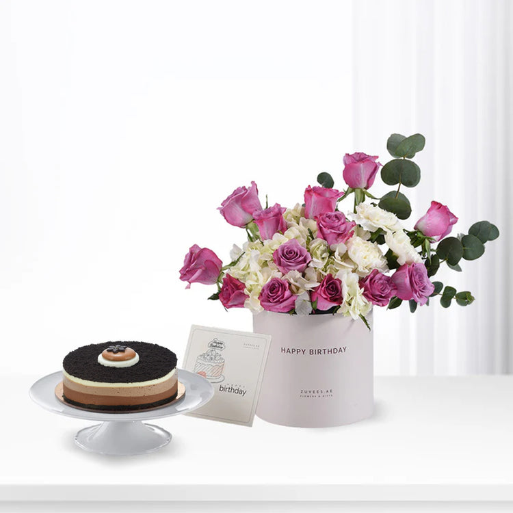 Pink roses, white hydrangeas, and chocolate cake in elegant birthday gift set.