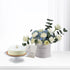 White cake and floral arrangement in minimalist birthday gift set.