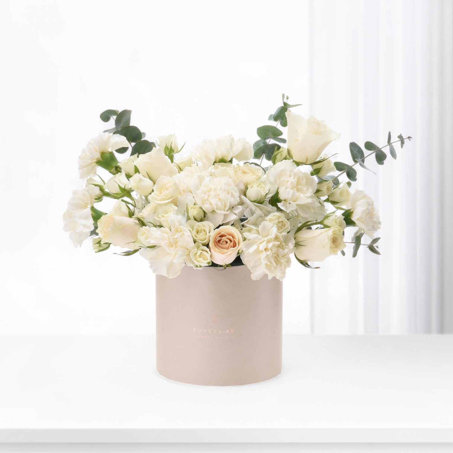 Elegant ivory roses and carnations in blush box, minimalist white backdrop.