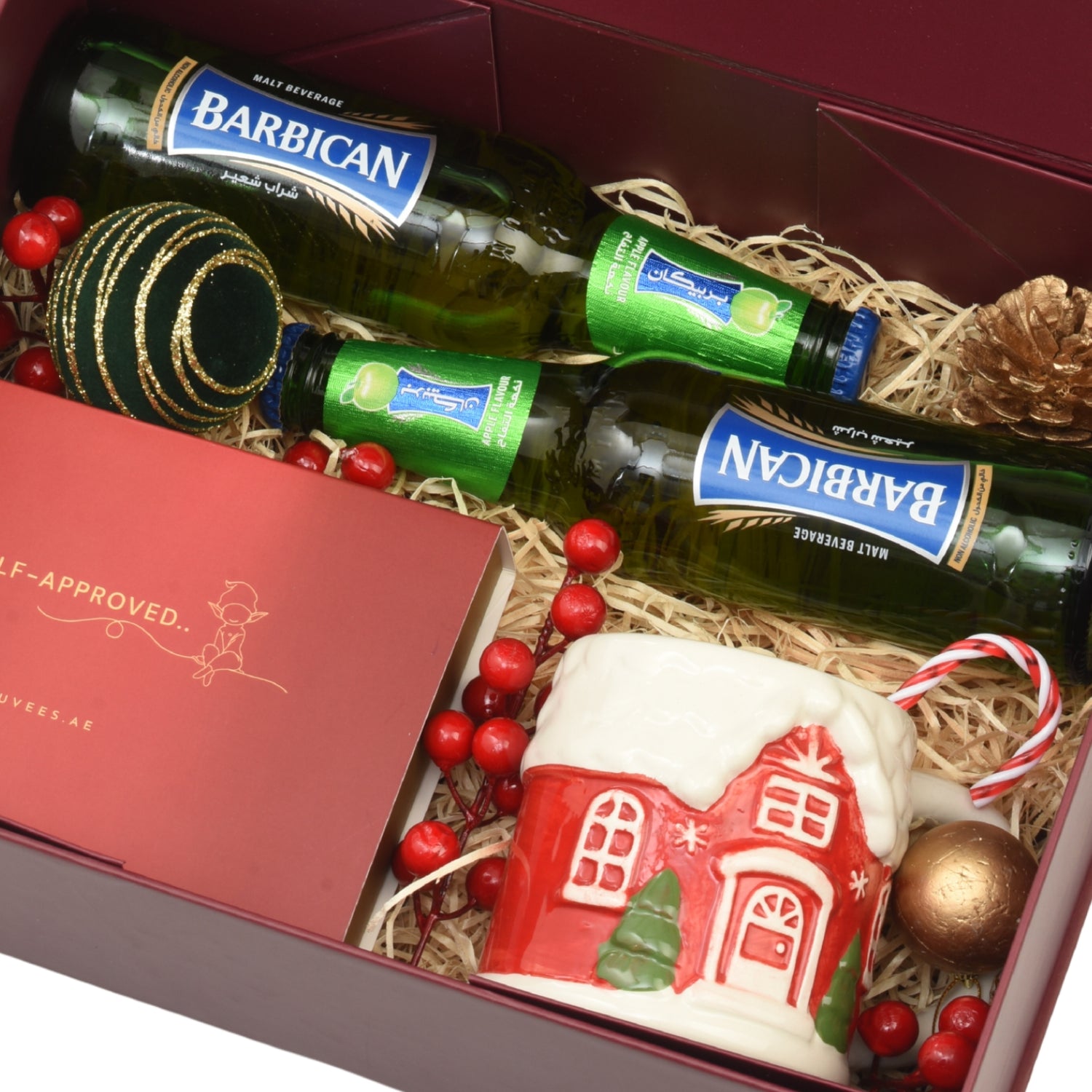 Luxury red gift box with Barbican malt beverages, festive mug, and holiday ornaments.