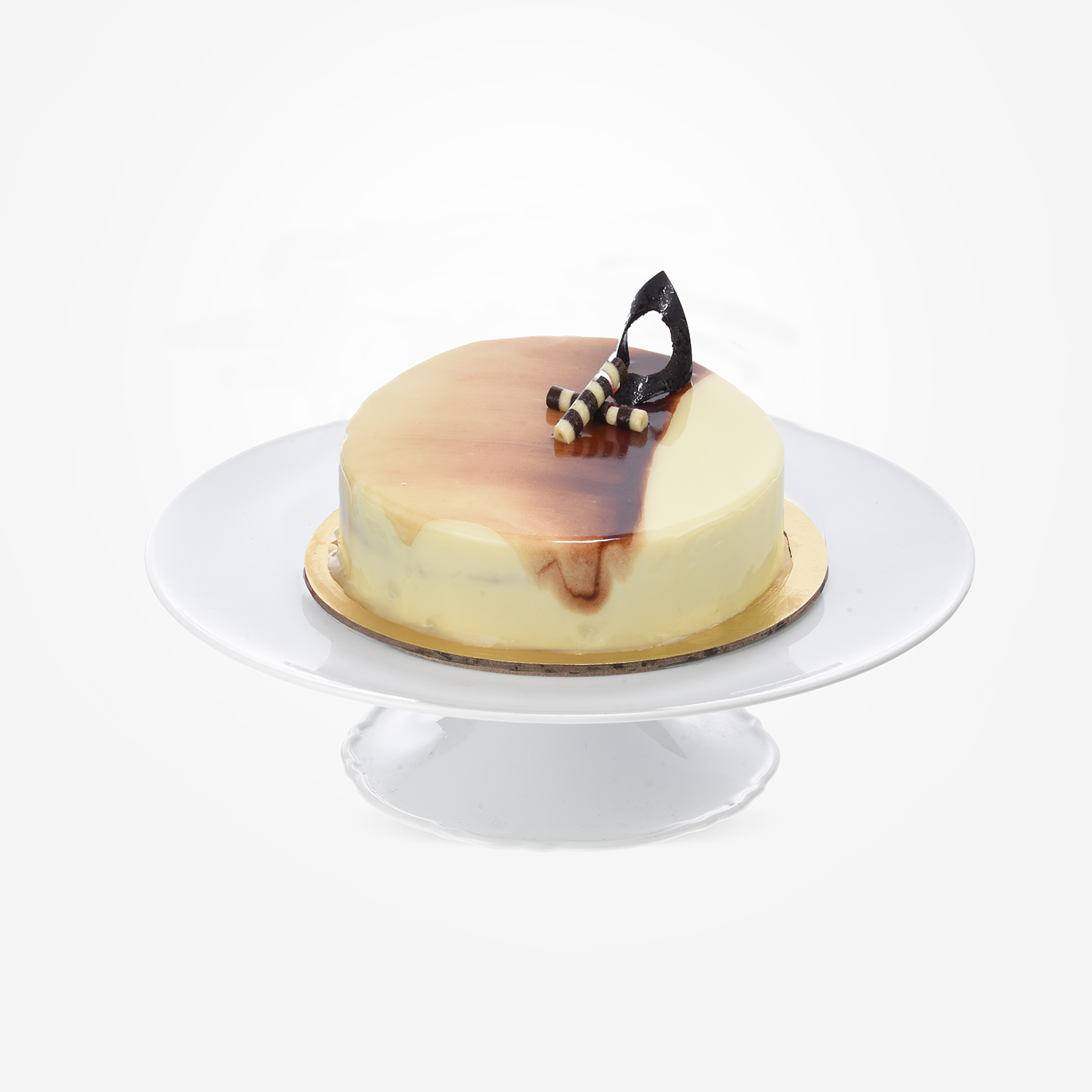 Creamy cake with glossy caramel drizzle and chocolate garnish on white stand.