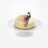 Creamy cake with glossy caramel drizzle and chocolate garnish on white stand.