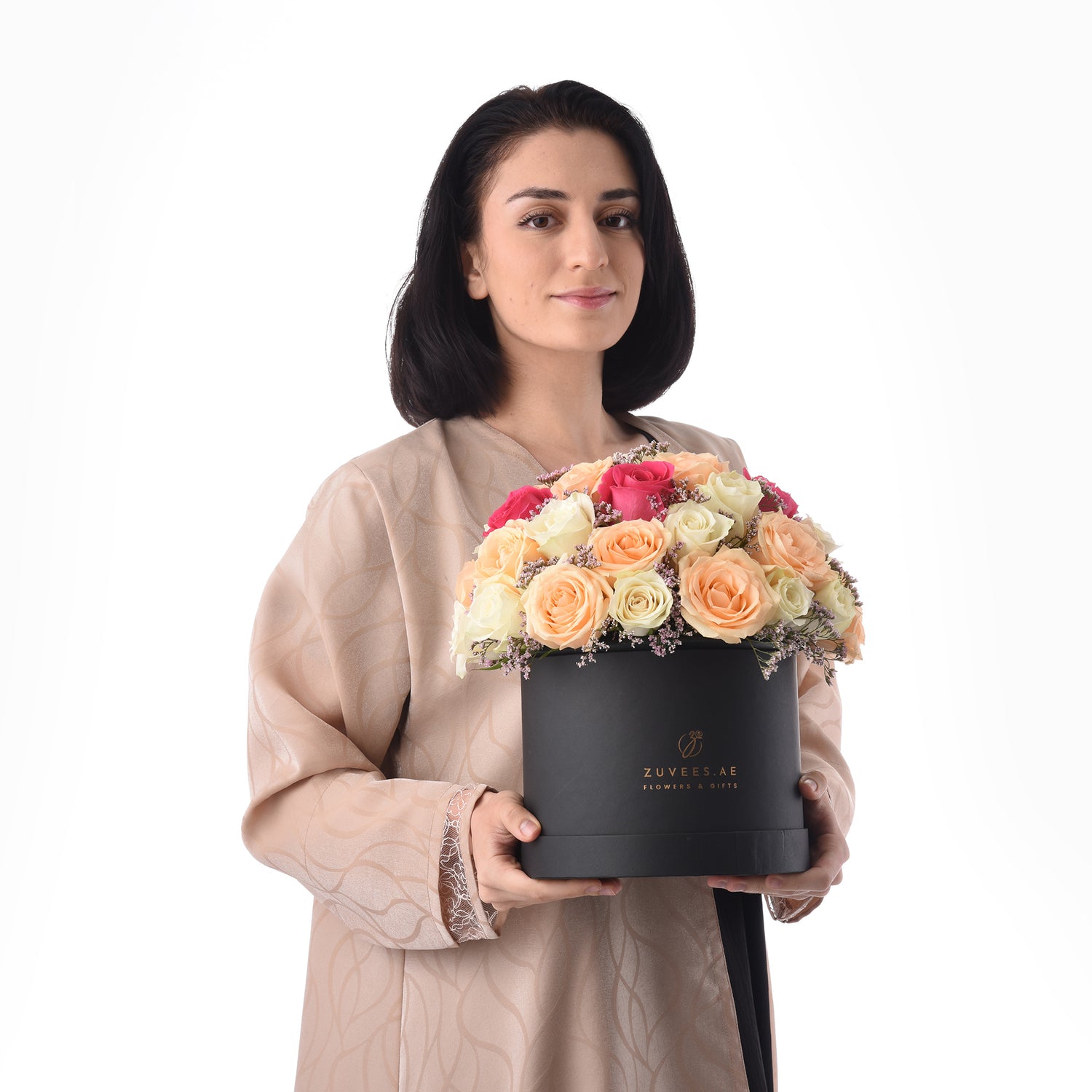 Elegant woman holds black box of vibrant multi-colored roses.