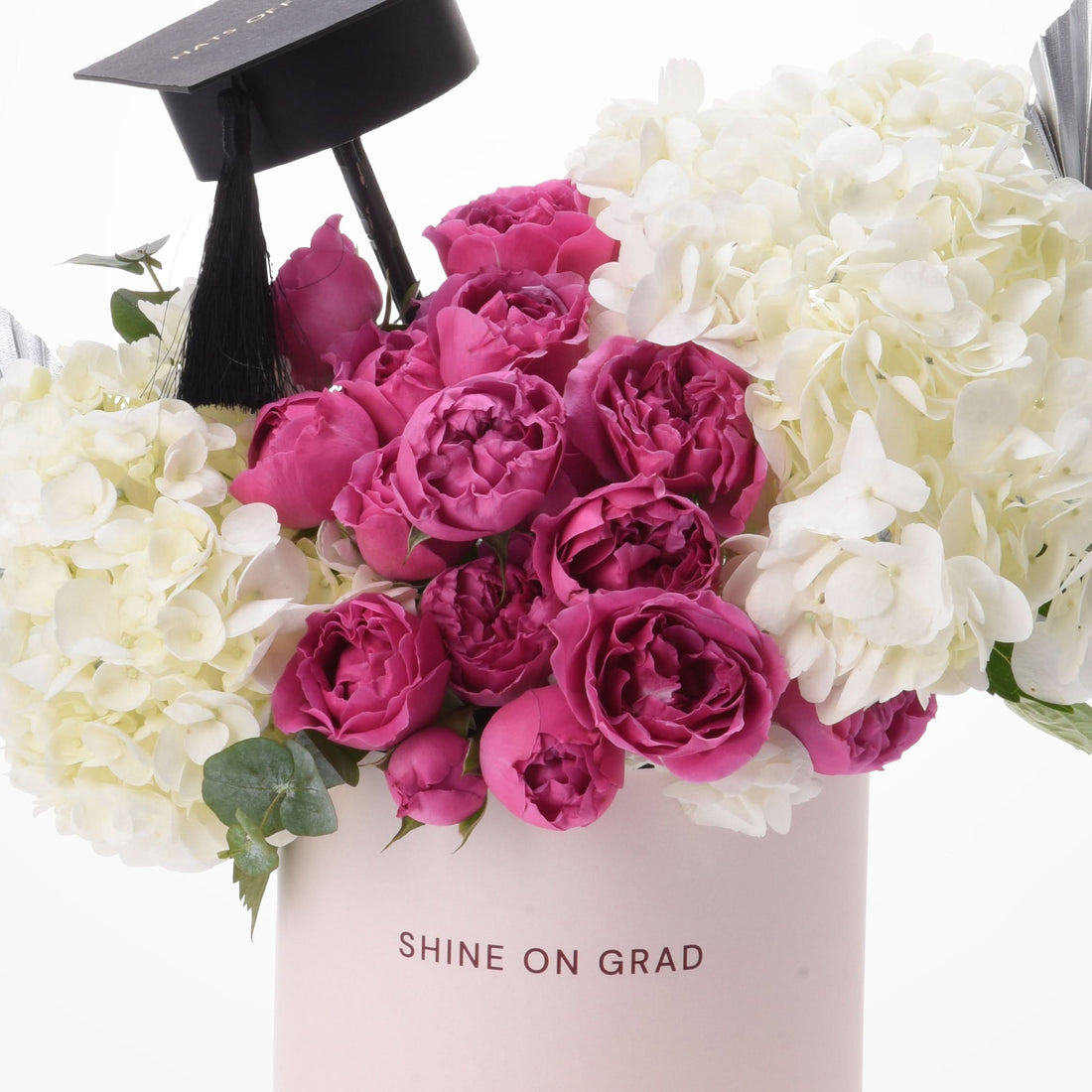 Pink roses and white hydrangeas crowned with graduation cap.