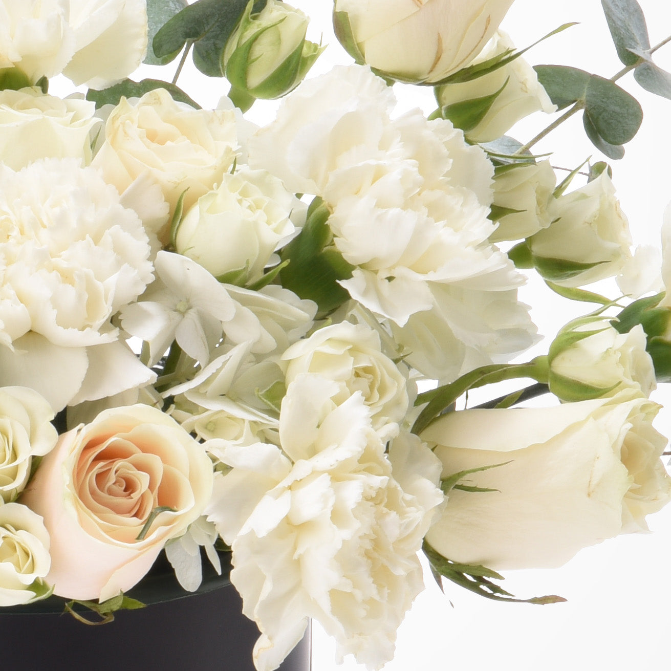 Cream roses, carnations, and eucalyptus in soft white and blush, elegant floral arrangement.