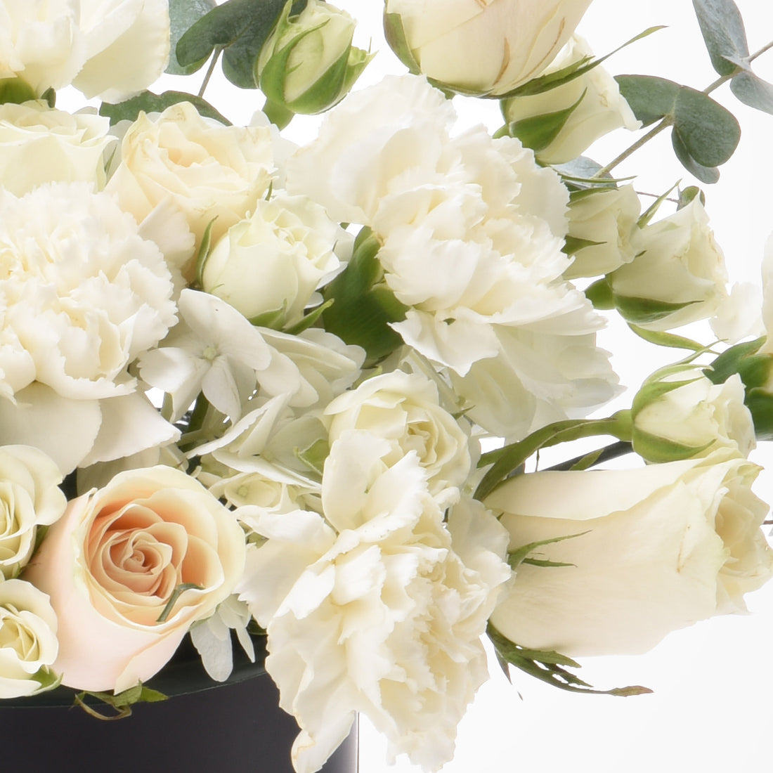 Elegant white and blush rose bouquet with lush textures and greenery.