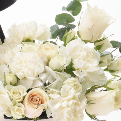 Elegant white rose and carnation bouquet accented with eucalyptus.