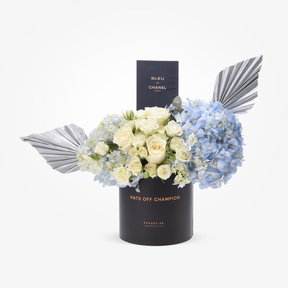 Elegant white roses, blue hydrangeas, silver leaves in black "Hats Off Champion" box with Bleu de Chanel.