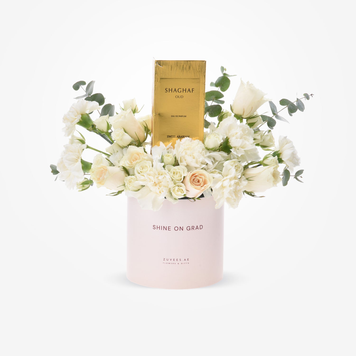 Elegant white floral arrangement with gold perfume box in blush container.