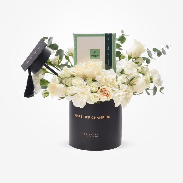 Elegant white roses and carnations in black graduation-themed vase with “Hats Off Champion” text.