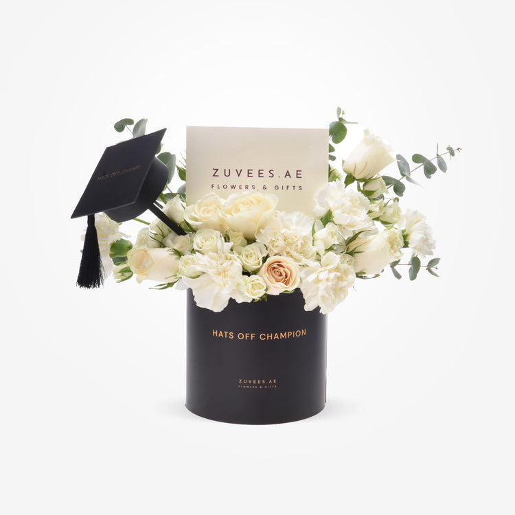 Elegant white roses and eucalyptus in black graduation-themed vase with "Hats Off Champion" message.