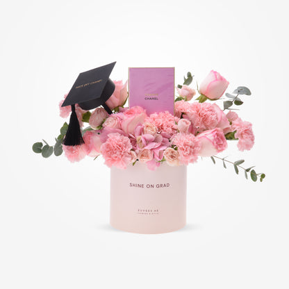 Pink roses and carnations in a "Shine On Grad" box with graduation cap and Chanel perfume.